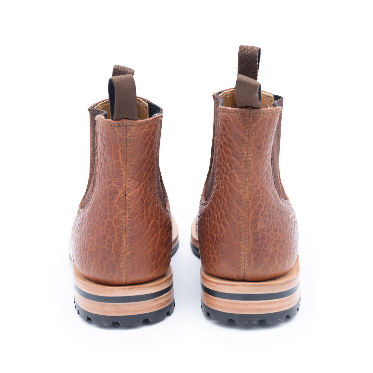 Pair of brown leather boots with a textured finish on a white background